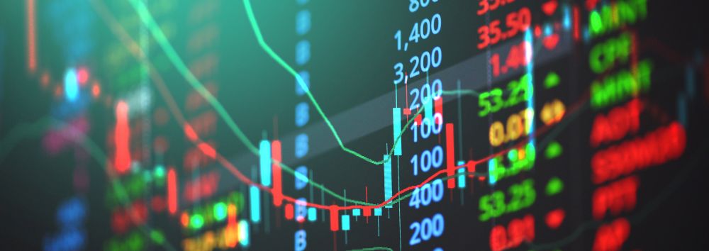 Digital stock market chart with candlestick patterns, price data, and fluctuating green and red lines representing market trends.