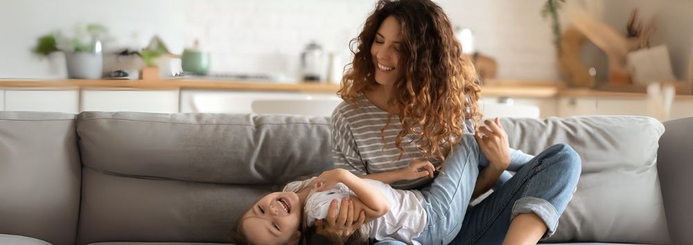 Protecting what matters most mother tickling her child on the sofa